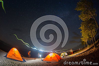 Hiking tourist have a rest in his camp at night near campfire Stock Photo