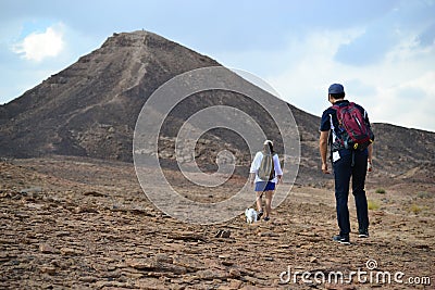 Hiking towards mountain at bottom of Makhtesh Ramon Crater, Mitzpe Ramon, Negev desert, Israel Editorial Stock Photo