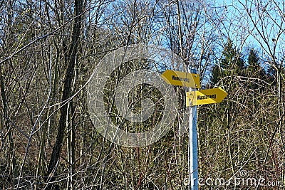 Hiking trail arrow shaped signposts in German language showing in two different directions. Stock Photo
