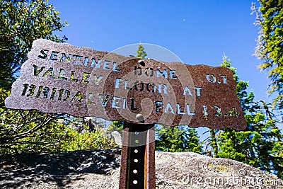 Hiking trail sign posted on the trail to Sentinel Dome, close to Glacier Point, showing points of interest and distances; Yosemite Stock Photo