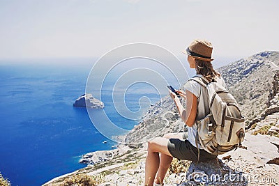 Hiking woman using smart phone taking photo, travel and active lifestyle concept Stock Photo