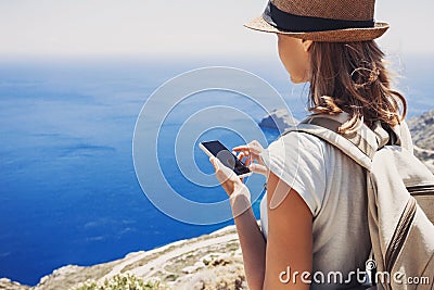 Hiking woman using smart phone taking photo, travel and active lifestyle concept Stock Photo