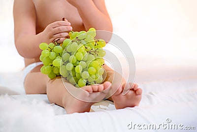 ?hild`s legs grapes on a white background eat. Stock Photo
