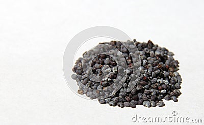 Hill of poppy seeds on white paper Stock Photo