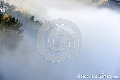 Hill in the sunrise misty fog and clouds Stock Photo