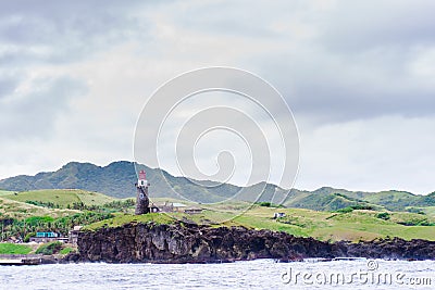 Hills of Sabtang Island with Lighthouse fronting the shore at, Batanes, Philippines Stock Photo