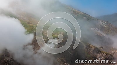 The hillside is shrouded in thick steam from an erupting geyser Stock Photo