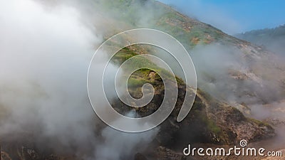 The hillside is shrouded in thick steam from an erupting geyser. Stock Photo