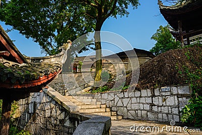 Hillside stairway in ancient tile-roofed buildings on sunny day Stock Photo