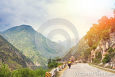 Himalayas landscape with two cyclist, mountains, road, river and clouds Stock Photo