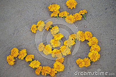 Hindi alphabet letter of Hindu holy Om written with yellow marigold flowers Stock Photo