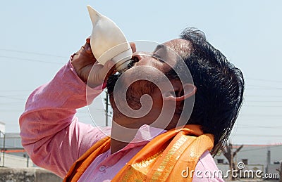 Hindu blowing conch a tradition in religious vents Editorial Stock Photo