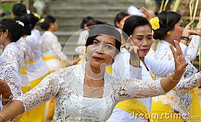 Hindu celebration at Bali Indonesia, religious ceremony with yellow and white colors, woman dancing. Editorial Stock Photo