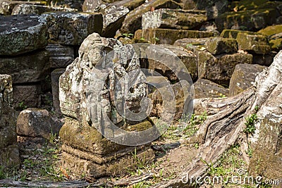 Hindu god mossy stone statue. Angkor Wat temple, Cambodia. Vishnu god statue. Ancient temple ruin in Siem Reap. Stock Photo