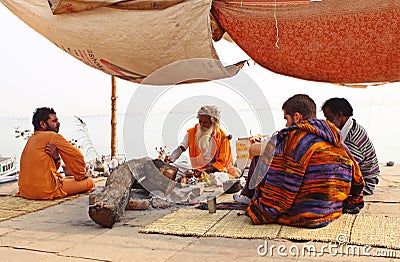 Hindu monk and followers on river bank, Varanasi Editorial Stock Photo