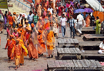 Hindu piligrims sadhu in orange clothes on the streets in India Editorial Stock Photo
