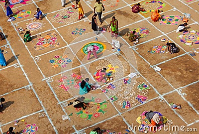 Hindu woman draw rangoli with colored powders,flowers in pongal or makara sankranti festiva Editorial Stock Photo