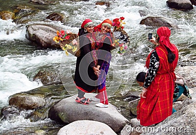 Young women in colorful clothes on a river bank wi Editorial Stock Photo