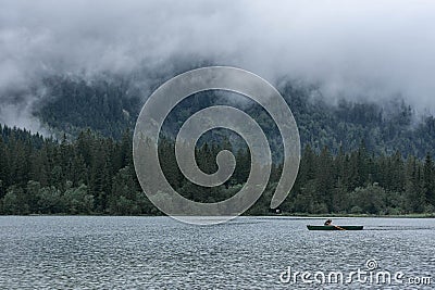 HINTERSEE, GERMANY, 3 AUGUST 2020: Lonely boat sailing in the foggy Intersee Lake in Bavaria Editorial Stock Photo