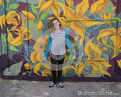 Hip eleven year old girl in front of a garage door mural in South Philadelphia Stock Photo