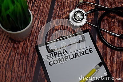 HIPAA Compliance write on paperwork isolated on wooden table Stock Photo