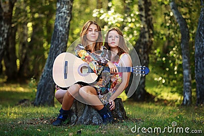 Hippie girls with guitar in a forest Stock Photo