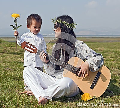 Hippie Woman playing Guitar with Son Stock Photo