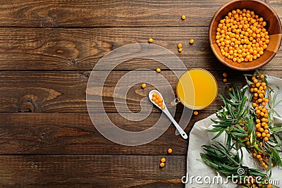 Hippophae juice, sea buckthorn berries on wooden table. Flat lay composition, top view. Natural organic autumn beverage Stock Photo