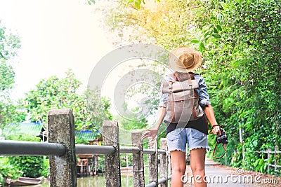 Hipster asian girl with camera breathing and looking at tropical walkway and canal, Tourist Traveler in Asia Stock Photo