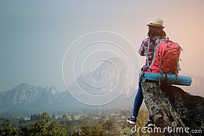 Hipster asian young girl with backpack enjoying sunset on peak mountain. Travel Lifestyle adventure concept Stock Photo