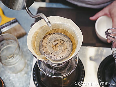 Hipster Barista making hand drip Coffee pouring water on filter Stock Photo