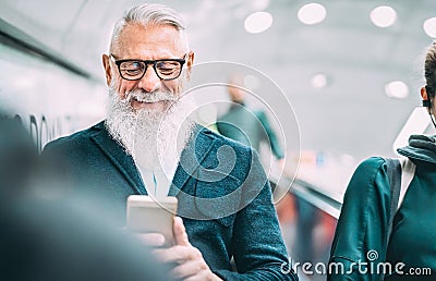 Hipster bearded man using mobile smart phone at shopping mall elevators - Trendy old person sharing content with smartphone Stock Photo