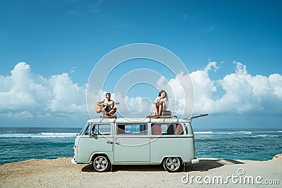 Hipster boy playing guitar with girlfriend on top of retro style Stock Photo