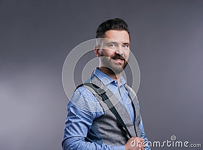 Hipster businessman in blue shirt, studio shot, gray background Stock Photo