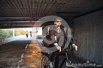 Hipster businessman commuter with electric bicycle traveling to work in city. Stock Photo