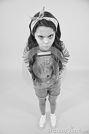Hipster child in bad mood. small girl yellow background. female hairdresser. angry retro kid wear colorful clothes Stock Photo