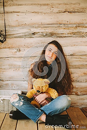 Hipster girl with a bear toy on a wooden background Stock Photo
