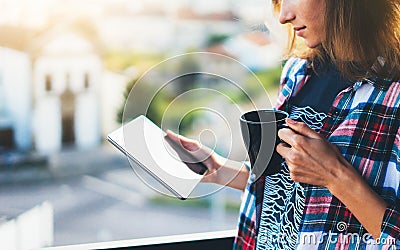 Hipster girl using tablet technology and drink coffee, girl person holding computer on background sun city, female hands texting Stock Photo
