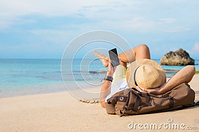 Guy with smartphone lying on the beach Stock Photo