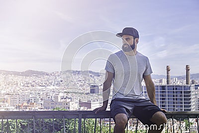 Hipster handsome male model with beard wearing gray blank t-shirt and a black snapback cap with space for your logo or Stock Photo