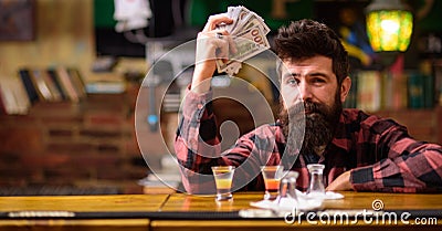 Hipster holds money, counting cash to buy more alcohol. Stock Photo