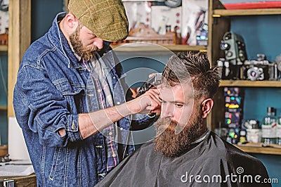 Hipster lifestyle concept. Hipster client getting haircut. Barber with hair clipper work on hairstyle for bearded Stock Photo