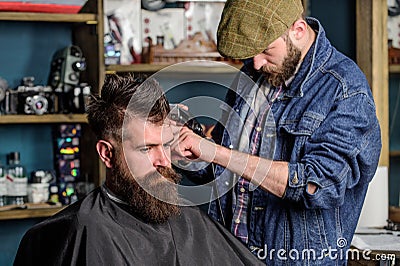 Hipster lifestyle concept. Hipster client getting haircut. Barber with hair clipper work on hairstyle for bearded Stock Photo