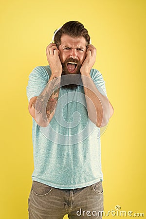 Hipster listen broken headphones music gadget. Hateful song. Music taste. Bearded guy dislike music. Irritating sound Stock Photo