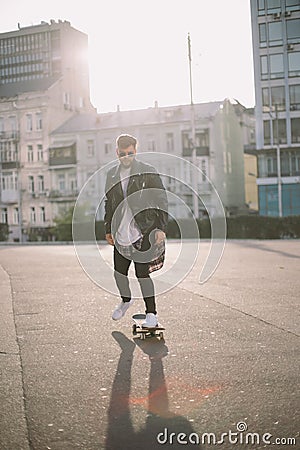 Hipster man with a beard portrait urban skateboarding Stock Photo