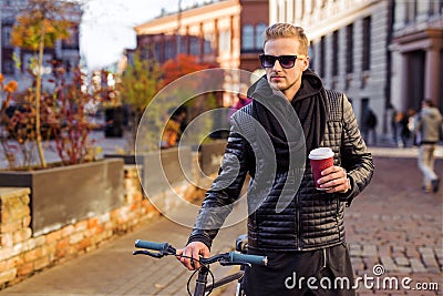 Hipster man with bicycle having morning coffee Stock Photo