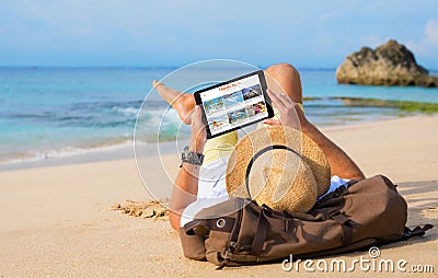 Man reading travel blog on beach Stock Photo