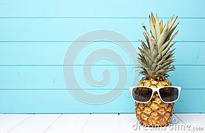 Hipster pineapple with sunglasses against blue wood Stock Photo