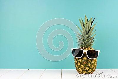 Hipster pineapple with sunglasses against turquoise Stock Photo
