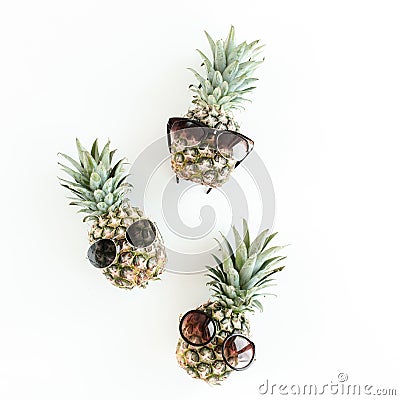 Hipster pineapples in glasses on white background. Flat lay, top view Stock Photo